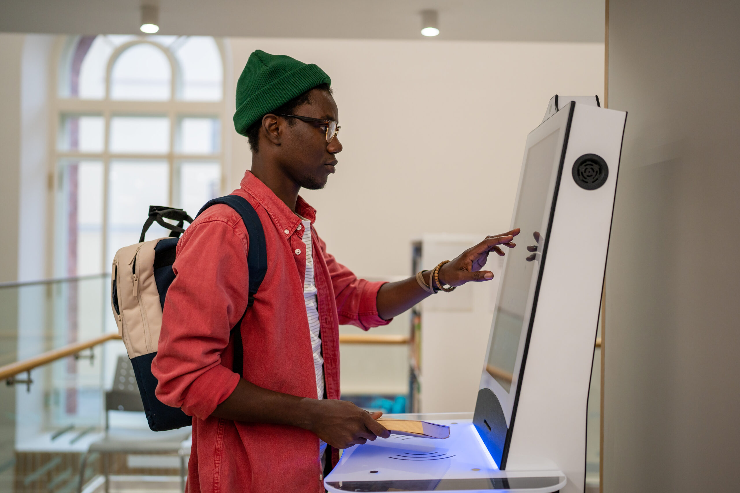 Progressive young man using self-service electronic terminal to pay in store without salesperson